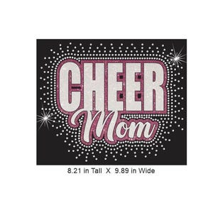 Może przedstawiać: Czarny grafika z napisem "CHEER Mom" w białym i r&oacute;żowym brokatem. Tekst otoczony jest r&oacute;żową brokatową obw&oacute;dką i białymi kryształkami. Grafika ma 20,85 cm wysokości i 25,12 cm szerokości.