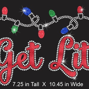 May include: A black graphic with the phrase "Get Lit!" in red glitter lettering, outlined with sparkling rhinestones. Above the text is a string of Christmas lights with red, blue, and green bulbs. The graphic is 7.25 inches tall and 10.45 inches wide.