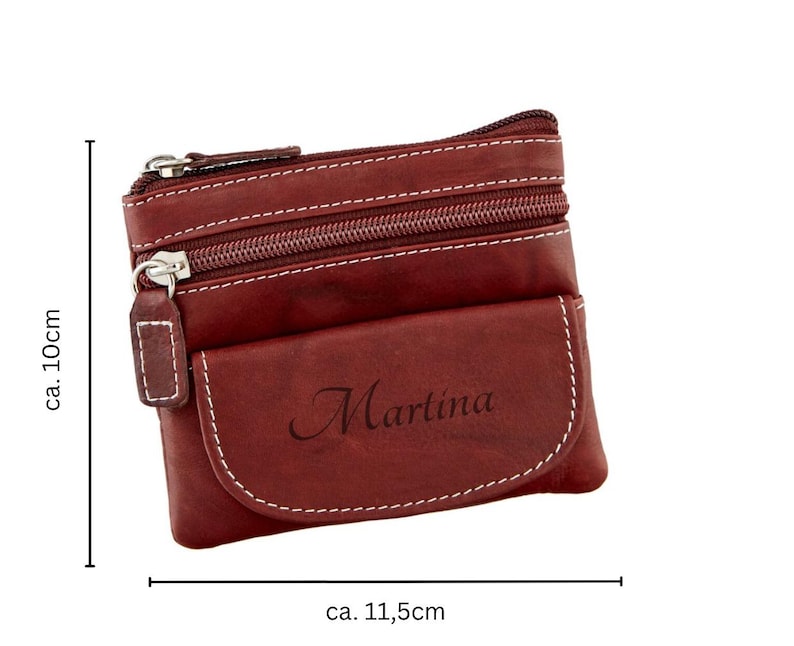 May include: A burgundy leather coin purse with white stitching and two zippered compartments. The purse has a front pocket with the name "Martina" printed on it. The purse is approximately 4 inches tall and 4.5 inches wide.