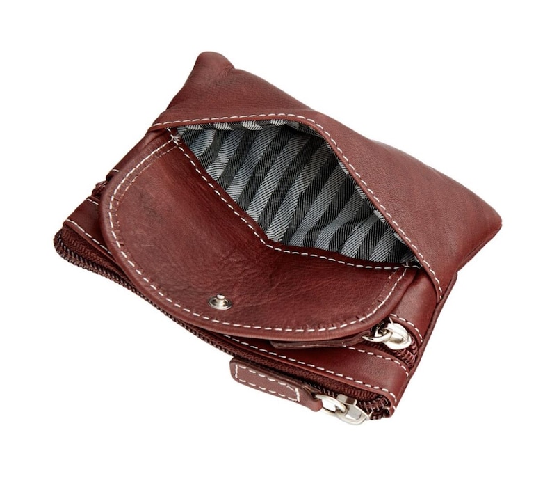 May include: A burgundy leather wallet with white stitching and a striped interior. The wallet has a zippered compartment and a snap closure. The open design reveals the interior lining.