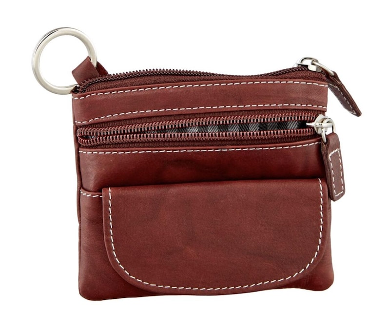 May include: A brown leather coin purse with white stitching and multiple zippered compartments. The purse has a key ring attached and a small front pocket. The zippers and key ring are silver-colored.