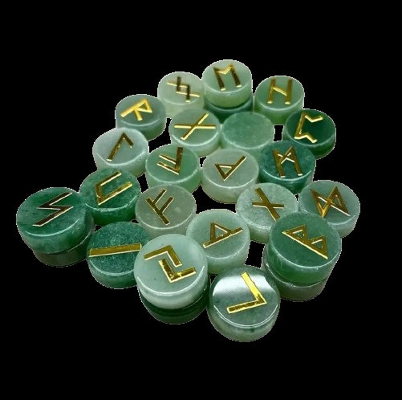 May include: Set of 18 green gemstone runes with gold lettering. Each rune is a different symbol from the Norse alphabet.