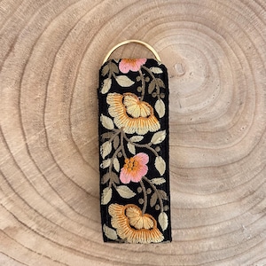 Blombroderad nyckelring med D-ring och blommotiv, kort nyckelrem med handledsögla och färgglada blommor i hippie-boho-stil
