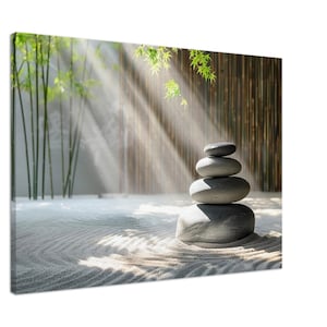 May include: A stack of grey stones in a zen garden setting. The stones are arranged in a pyramid shape and are surrounded by white sand. The background is a bamboo fence and green foliage. Sunlight streams through the foliage, creating a peaceful and serene atmosphere.