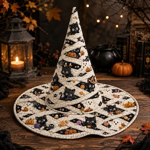 May include: A quilted witch hat featuring a repeating pattern of black cats, white ghosts, orange pumpkins, and candy corn on a black and white diamond background. The hat has a tall, pointed cone shape and a wide, circular brim with stitched details.