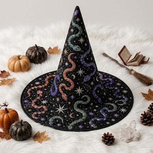 May include: A black pointed hat featuring a quilted texture and a colourful pattern of snakes, stars, and crescent moons in shades of purple, green, and orange. The hat has a wide, circular brim and a tall, conical crown with detailed stitching.