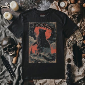 May include: Black t-shirt with a graphic print of a black cat with a red moon in the background. The text "MEOWWWWWW" is printed above the cat.