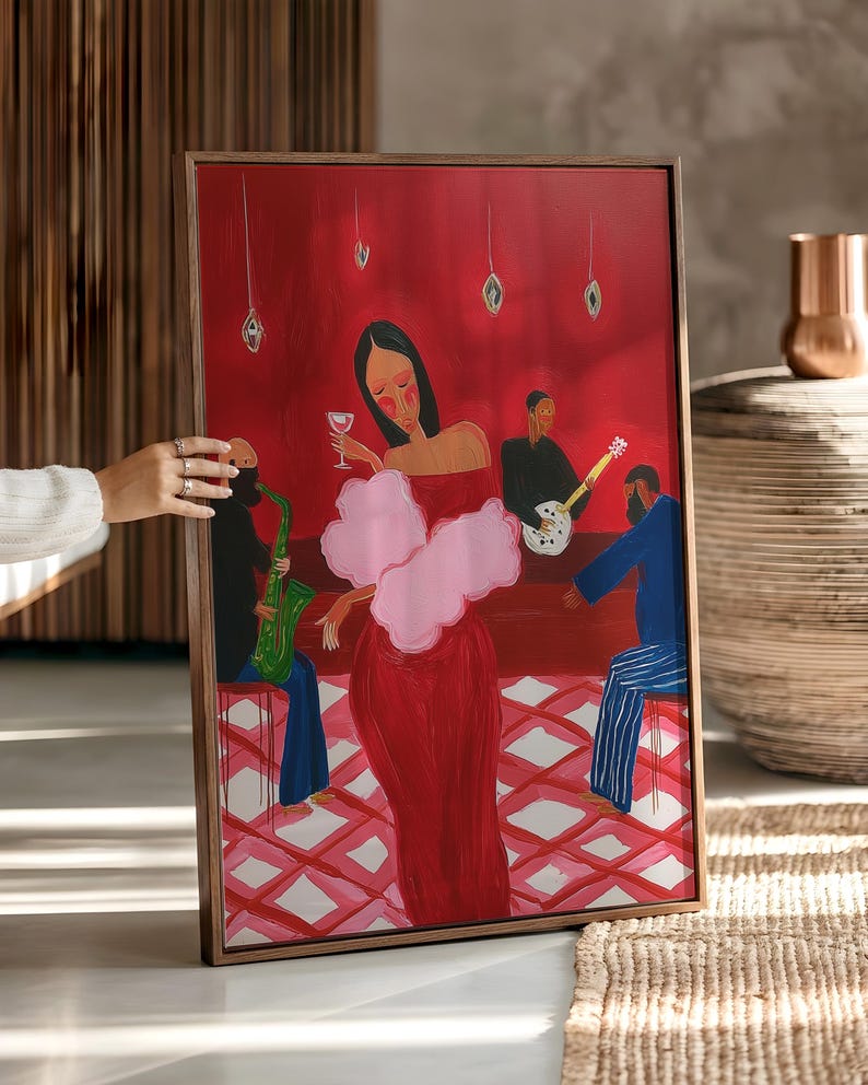 May include: A framed art print depicts a jazz club scene. A woman in a red dress and pink boa holds a wine glass. Musicians play saxophone and guitar. The background is red with diamond-patterned flooring.