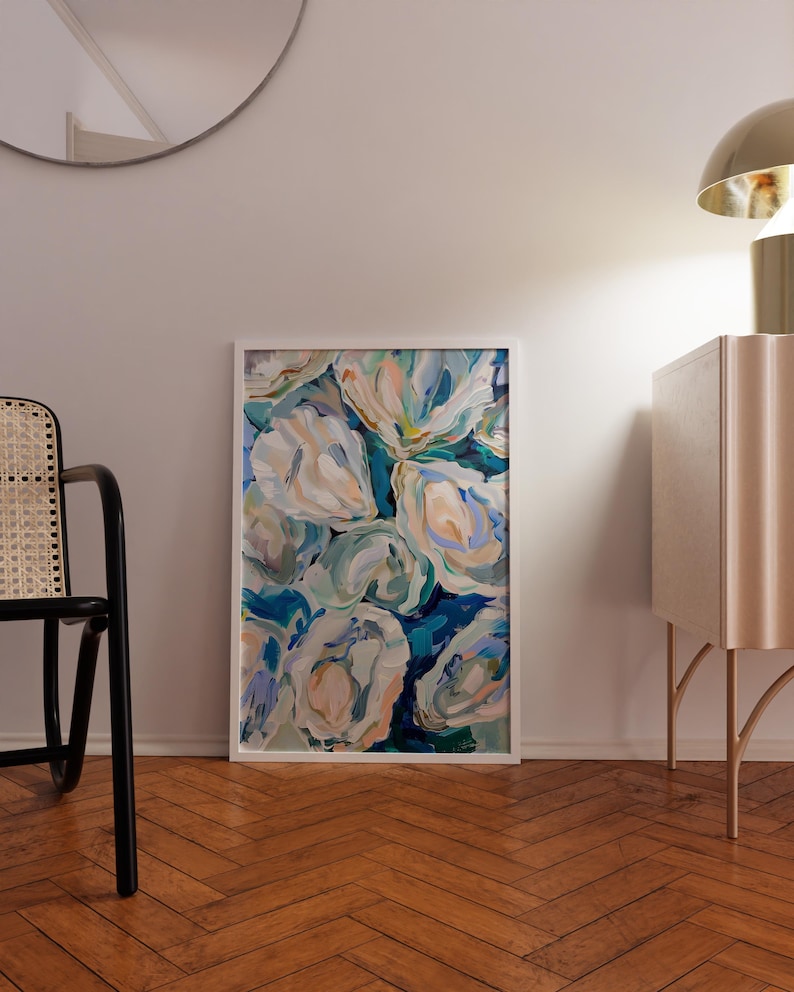 K&ouml;nnte beinhalten: Ein gerahmtes abstraktes Gem&auml;lde mit wei&szlig;en, blauen und gr&uuml;nen floralen Formen auf blauem Hintergrund. Das Gem&auml;lde h&auml;ngt an einer wei&szlig;en Wand in einem Raum mit Holzboden.