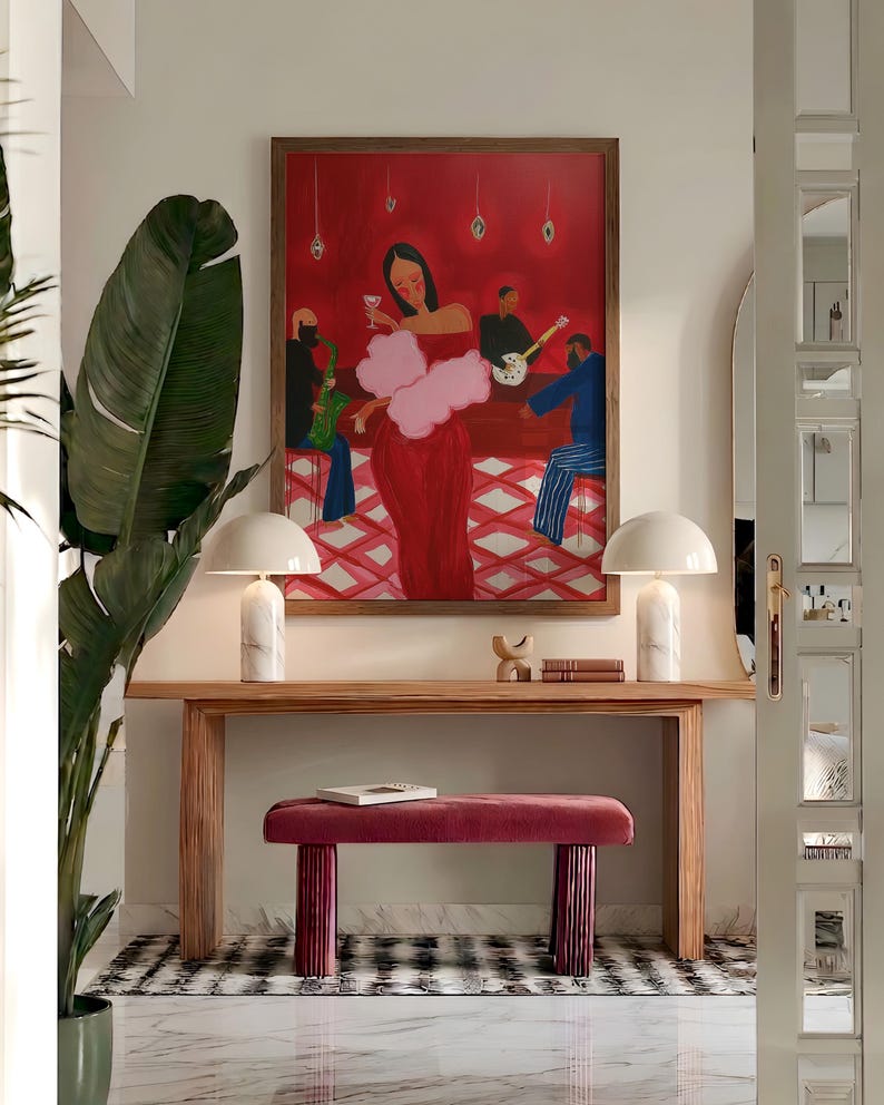 May include: An interior scene featuring a large painting of a woman in a red dress in a bar setting. A wooden console table holds two white lamps and a small bench. The floor has a black and white checkered pattern.