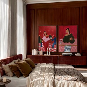 May include: A bedroom scene featuring a bed with a red headboard and a leopard-print blanket. Two framed paintings with red backgrounds hang above a red cabinet. The room has wood paneling and sheer curtains.