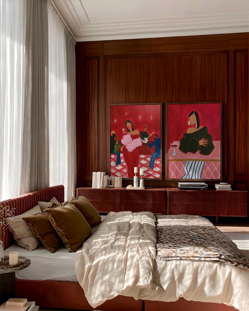 May include: A bedroom scene featuring a bed with a red headboard and a leopard-print blanket. Two framed paintings with red backgrounds hang above a red cabinet. The room has wood paneling and sheer curtains.