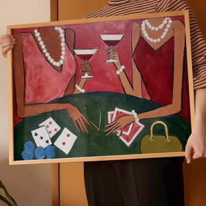 May include: An abstract painting in a wooden frame depicts two figures in red dresses, holding wine glasses. A green table displays playing cards, dice, and a purse. The figures wear pearl necklaces and bracelets. The background is red.
