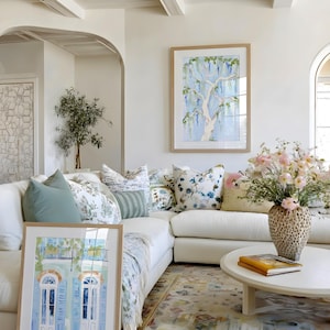 Puede incluir: Un sal&oacute;n luminoso y espacioso con un sof&aacute; esquinero blanco, cojines decorativos y una mesa de centro redonda. Dos pinturas de acuarela enmarcadas se apoyan en el sof&aacute;. Un jarr&oacute;n con flores rosas est&aacute; sobre la mesa.
