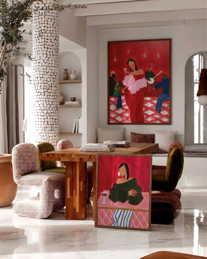 May include: An interior scene featuring a large framed painting of a woman in a red dress holding a glass of wine. A smaller painting with a similar theme is on the floor. The room includes a wooden table, chairs, and decorative elements, creating a stylish and artistic ambiance.