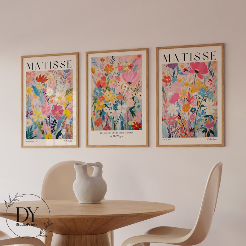 May include: Three framed art prints with a floral design. The prints are in a light wood frame and feature a colorful abstract floral design with pink, yellow, blue, and green flowers. The prints are titled "Matisse" and feature the text "8, Rue de l'Universite, Paris H. Matisse".