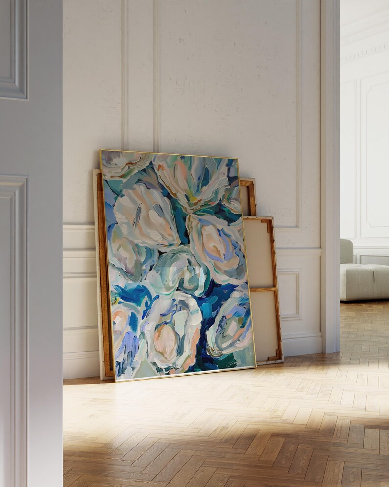 K&ouml;nnte beinhalten: Abstrakte Malerei von blauen, gr&uuml;nen und wei&szlig;en Blumen in einem goldenen Rahmen. Das Gem&auml;lde lehnt an einer wei&szlig;en Wand.