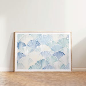 May include: A framed print with a blue and white watercolor pattern of overlapping fan shapes. The background is a light cream color.