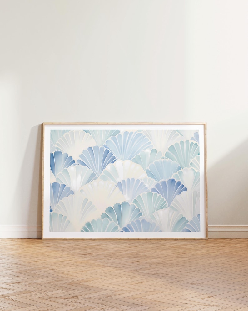 May include: A framed print with a blue and white watercolor pattern of overlapping fan shapes. The background is a light cream color.
