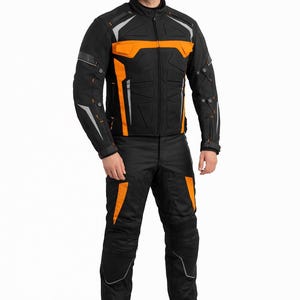 Puede incluir: Conjunto de chaqueta y pantalón de moto negros con detalles en naranja y plata. La chaqueta presenta paneles naranjas en el pecho y los hombros, con rayas reflectantes plateadas. Los pantalones tienen detalles naranjas a juego y protecciones en las rodillas. Diseñado para motociclismo.