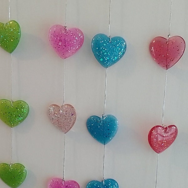 Garland, hearts, made with resin, colour dye & glitter, tied with silver thread, hang vertically. Colourful red,blue,green,purple,pink,lemon