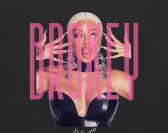Peut inclure: Une pochette d'album rose et noire avec le mot "BROKEN" en grandes lettres roses. La pochette présente une femme aux cheveux blonds portant un haut en cuir noir et un collier argenté. La femme sort sa langue et a de longs ongles roses et noirs.