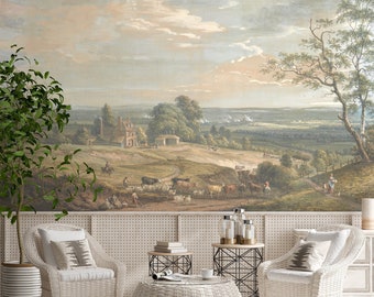 Puede incluir: Una mesa de centro de mimbre blanco con tapa de cristal se encuentra frente a un mural de pared que representa un paisaje campestre con una granja y colinas onduladas. Dos sillas de mimbre blanco con cojines y almohadas blancas se colocan a ambos lados de la mesa de centro.