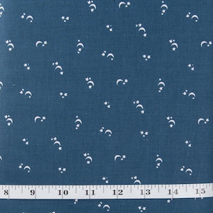 May include: A teal blue fabric with a white crescent moon and star pattern. The fabric is measured with a white tape measure.