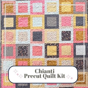May include: A patchwork quilt with a repeating square pattern in shades of pink, gold, blue, and gray. The quilt features intricate quilting details and the text "Chianti Precut Quilt Kit" in a decorative banner.