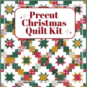 May include: A Christmas quilt kit with a festive design. The quilt features a patchwork pattern with red, green, and gold squares and star-shaped accents. The text "Precut Christmas Quilt Kit" is displayed in a red banner.