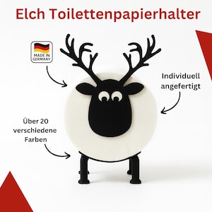 Könnte beinhalten: Ein weißer Toilettenpapierhalter in Form eines Schafs mit schwarzen Geweih, Gesicht und Beinen. Der Text "Elch Toilettenpapierhalter" steht oben. Hergestellt in Deutschland, individuell anpassbar in über 20 Farben.