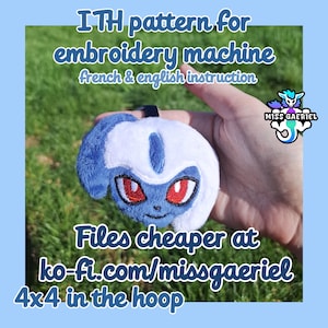Op de afbeelding: Een blauw en wit pluche karakter met rode ogen en een lachend gezicht. De tekst "ITH pattern for embroidery machine" en "4x4 in the hoop" zijn zichtbaar. De tekst "French & English instruction" en "Files cheaper at ko-fi.com/missgaeriel" zijn ook aanwezig.