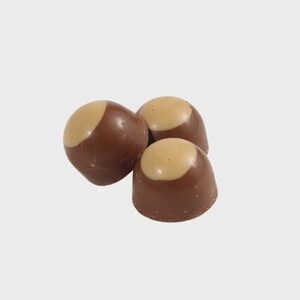 May include: Three chocolate candies with a light brown, rounded top and a dark brown base. The candies are arranged in a cluster, with a plain white background.