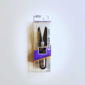 May include: A pair of black Clover thread snips in a clear plastic retail package. The packaging features the text Clover, 36-399, and 10.5cm. The snips have rounded tips and black blades, with Japanese text printed on the purple and white label.
