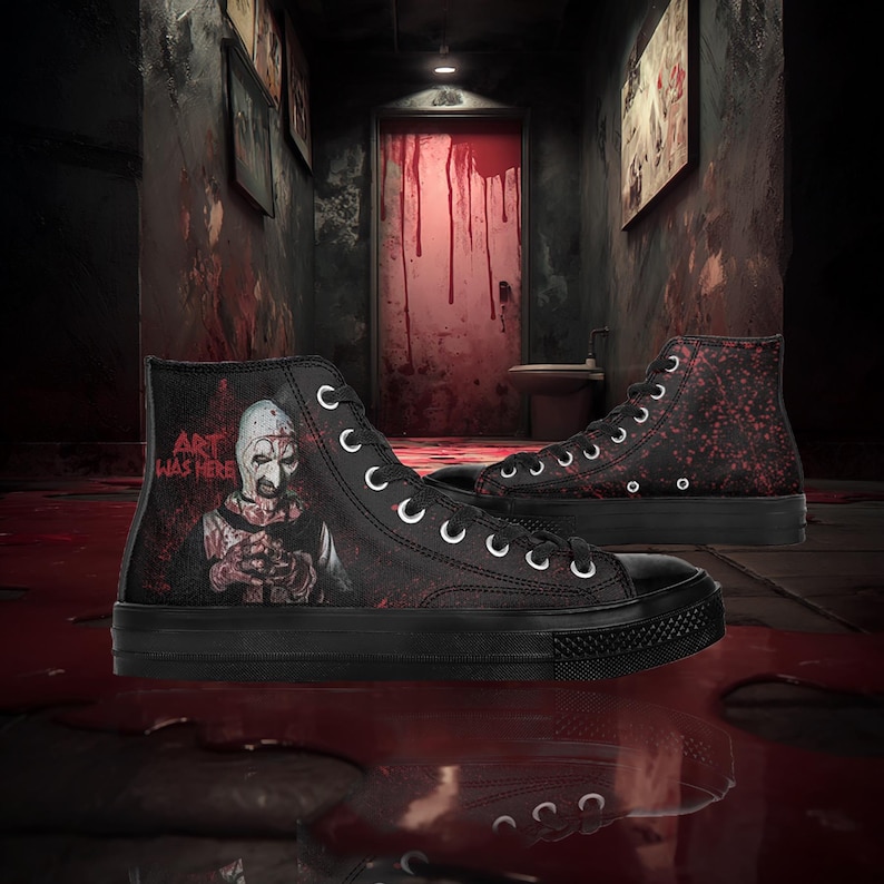 May include: Black high-top trainers with a horror-themed design. One trainer features a graphic of a character with the text "ART WAS HERE." The other has a red splatter pattern. Both have black soles and white laces.