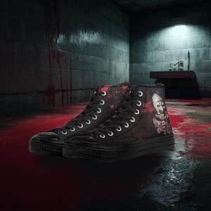 May include: Black high-top trainers with white laces. The canvas uppers feature a graphic of a character with the text "ART HAS HERE" and red splatter details. The shoes have black rubber soles.