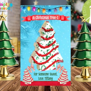 May include: A Christmas-themed image featuring two decorative green Christmas trees with gold bases and star toppers flanking a greeting card. The card has a Christmas tree design with red and green accents, and the text "A Christmas Tree-t".