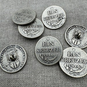 Könnte beinhalten: Sechs silberfarbene Metallknöpfe mit der Aufschrift "Ein Kreuzer 1816" und einem Stern. Die Knöpfe haben ein erhabenes Design aus einem Kranz und einem Buchstaben "A".