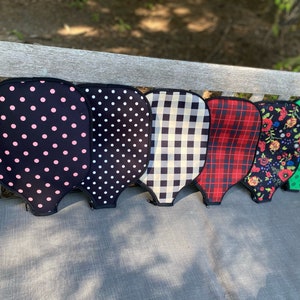 Pu&ograve; includere: Sei diverse racchette da pickleball con motivi diversi, tra cui pois rosa e neri, pois neri e bianchi, gingham bianco e nero, tartan rosso e nero, floreali e verdi.