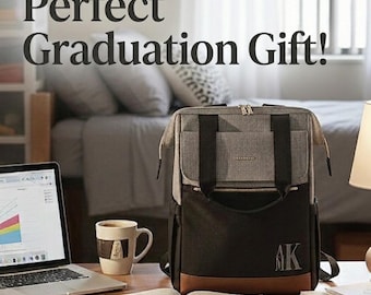 May include: A gray, black, and brown backpack with the text "Perfect Graduation Gift!" is displayed on a wooden desk. The backpack has a monogram with the letters "AK". A laptop, coffee mug, and open book are also on the desk.