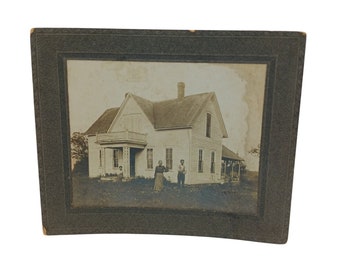 Antikes, mattiertes Foto, altes Haus, Mann und Frau im Garten, Frau sitzt auf der Veranda