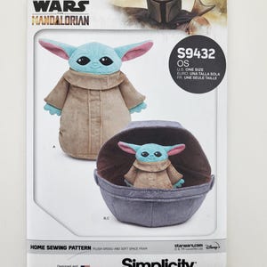 K&ouml;nnte beinhalten: Ein Schnittmuster f&uuml;r einen Pl&uuml;sch-Grogu und einen weichen Weltraumkinderwagen. Das Muster zeigt Bilder des Grogu-Pl&uuml;schtiers, eines stehend und eines in einem Kinderwagen. Das Star Wars Mandalorian-Logo befindet sich oben, das Simplicity-Logo unten.