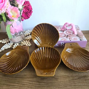 Peut inclure: Ensemble de quatre plats en céramique de couleur marron en forme de coquille. Les plats sont émaillés et ont une surface texturée.