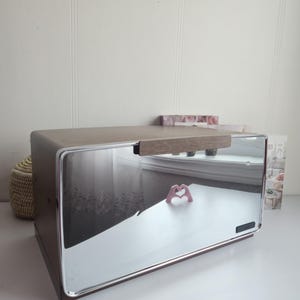 Op de afbeelding: Een set van drie keramische mokken met een gespikkelde, matte afwerking. De mokken zijn in de kleuren crème, lichtgrijs en donkergrijs. Elke mok heeft een eenvoudig, minimalistisch ontwerp. De mokken zijn ongeveer 10 cm hoog.