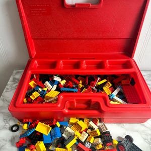 Vintage LEGO red figurines storage filled with brick construction legos lot.