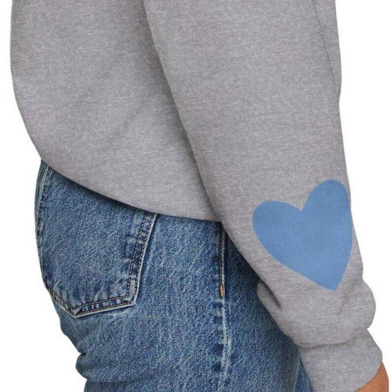 Sport grey crewneck sweatshirt featuring a large Carolina blue heart on the chest and a smaller matching Carolina blue heart on the right sleeve.