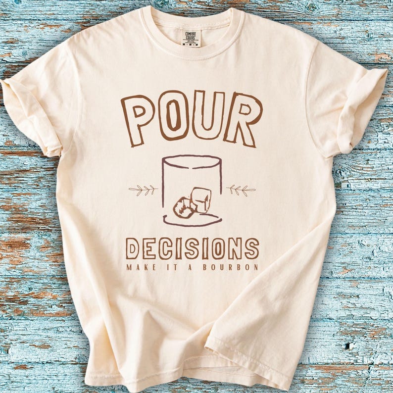 For the bourbon lovers! POUR DECISIONS (make it a bourbon) with a simple distressed line drawing of a whiskey glass with two ice-cubes. Brown graphics on ivory.