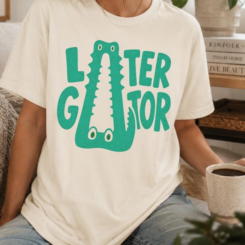 IVORY Comfort Colors graphic tee featuring a playful Later Gator alligator illustration forming the letter A in chunky retro green typography.