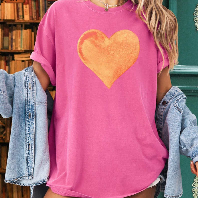 Comfort Colors pink t-shirt with watercolor orange heart design in blossom and crunchberry pink.