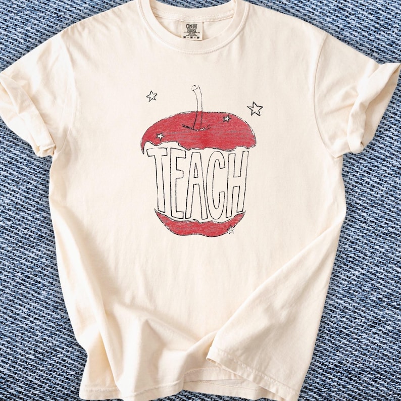 Hand drawn TEACH apple shirt for teachers on ivory tee, vintage childlike apple sketch with imperfect pencil lines and red crayon texture, Free People inspired teacher style